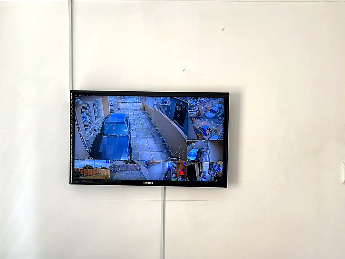 Wall-mounted screen showing a live multi-camera CCTV view