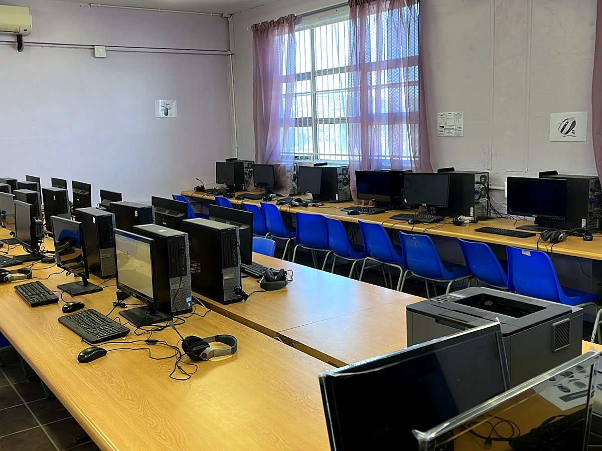 School computer lab with rows of networked desktop computers on long desks